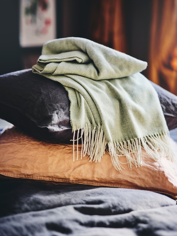 光灰绿色HOLMVI扔躺在枕头上的垫在黑暗的米色DYTAG靠垫。