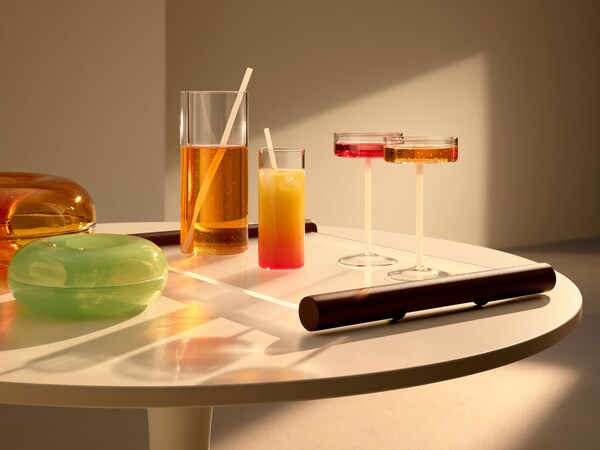 一个VARMBLIXT玻璃水瓶和眼镜VARMBLIXT玻璃托盘放在桌上,用VARMBLIXT甜甜圈形状的玻璃碗。