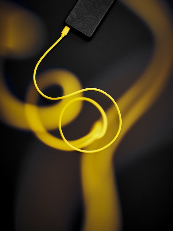 黄色SITTBRUNN充电电缆一端在黑色的电池组,和电缆绕线圈出来。