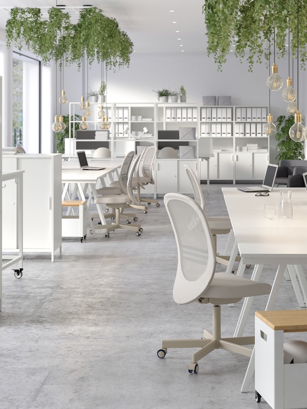 明亮和通风的办公空间与白色TROTTEN桌子组合形成合作领域。