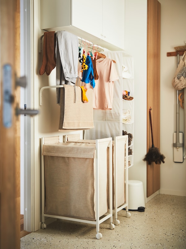 两个ENHET洗衣袋在白色,海狸香和物品挂在干燥架在墙上和开放存储在白色。