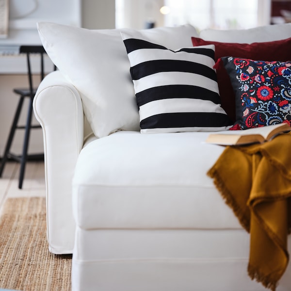 客厅,各种五颜六色的垫子和一把躺椅占领白色沙发GRONLID阀座的一部分。
