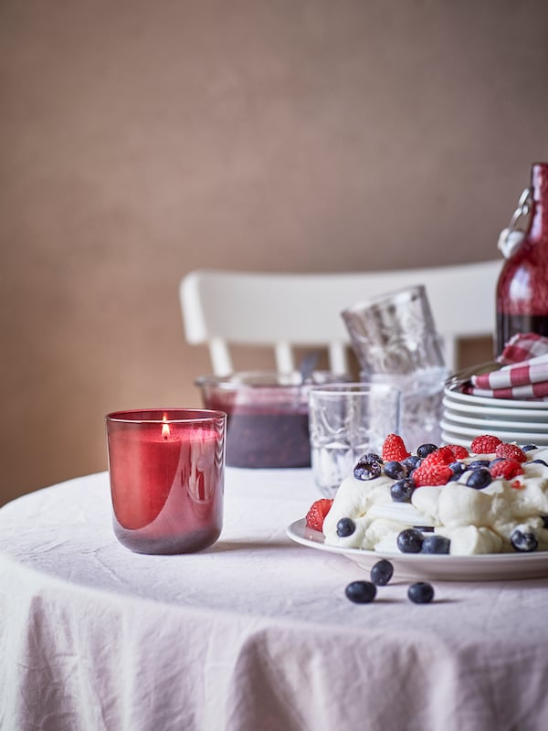 STORTSKON带香味的蜡烛在一套表玻璃罐草莓蛋糕庆祝一下,成堆的盘子和玻璃杯。