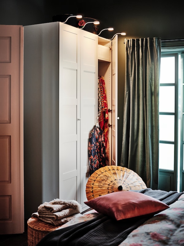 一间卧室和一个窗口月尾SANELA窗帘旁边PAX衣橱,里面一扇门半开暴露的衣服。