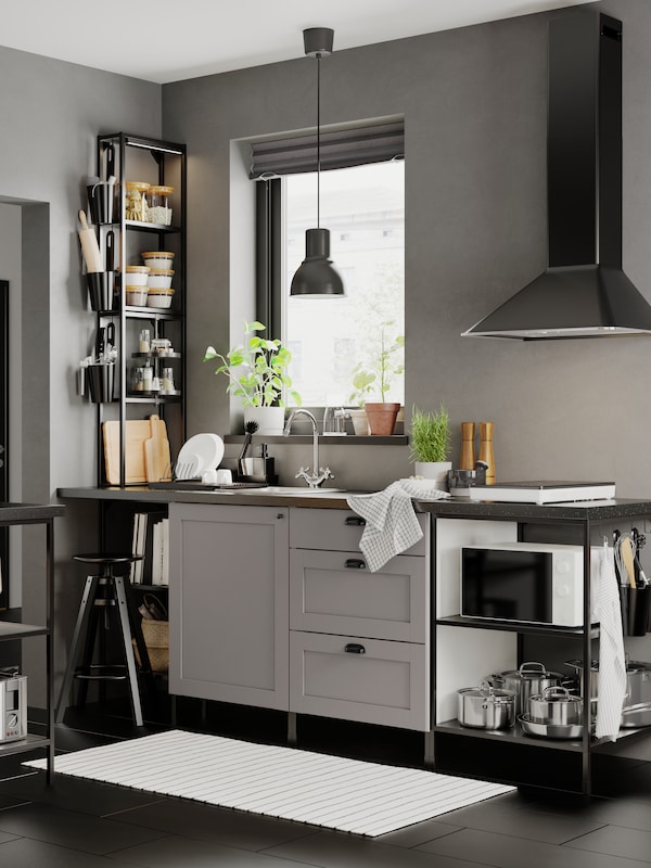 一个厨房ENHET MATTRADITION固定在墙上的排气罩在黑色和深灰色HEKTAR吊灯。