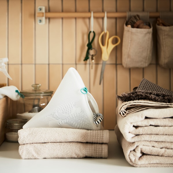 SLIBB洗涤袋与VINARN手巾在浅灰色/白色米色和物品挂在桦树NEREBY铁路。