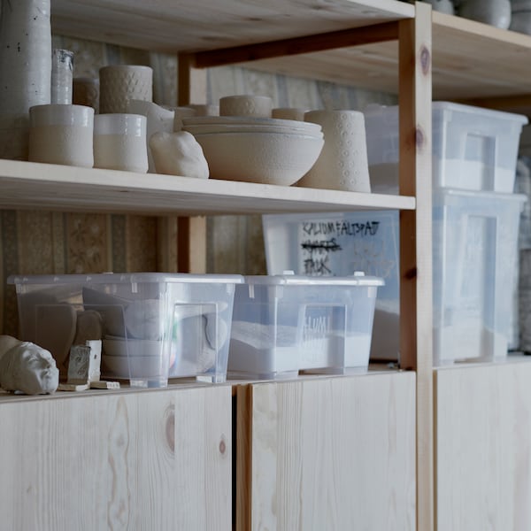IVAR搁置单位拿着碗,雕像和陶瓷配件,一些存储在透明SAMLA存储盒。