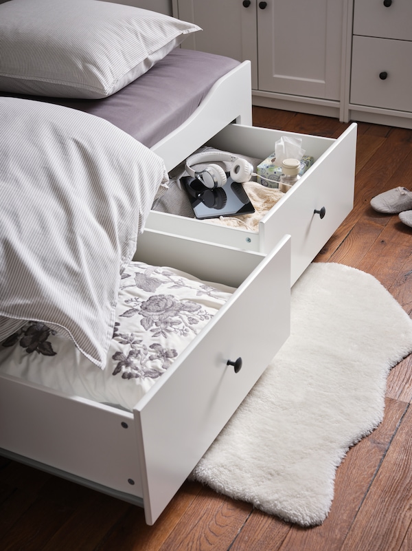 一个白色TOFTLUND地毯下面躺在地板上的两个打开抽屉HEMNES与3抽屉/ 2床垫的床。