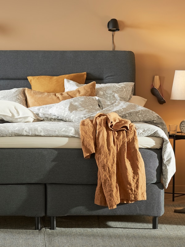 灰色与JATTEVALLMO FINNSNES沙发床床单白色/灰色和黄色的墙壁站在一间卧室。