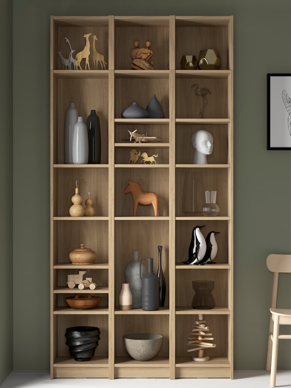 比利书柜结合扩展单位在橡木效果与装饰对象和花瓶的货架上。