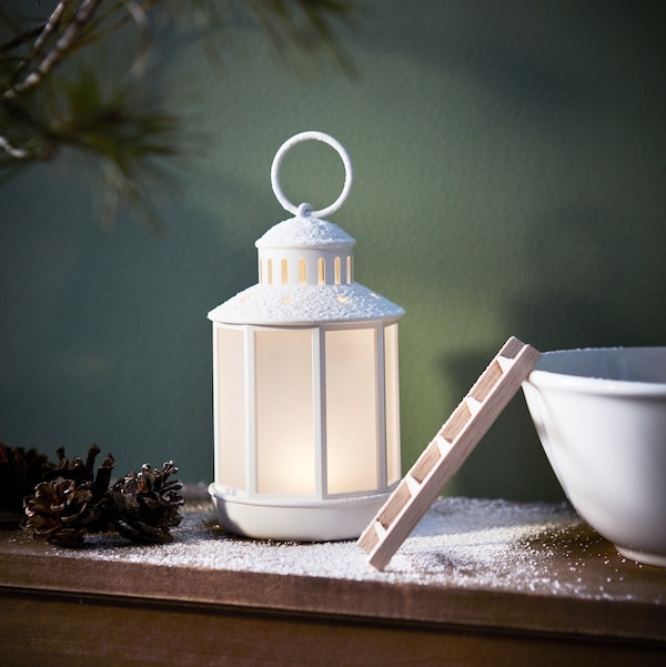 STRALA圣诞灯坐在一张桌子旁边,一个碗里,准备节日的季节。一棵圣诞树也可以看到