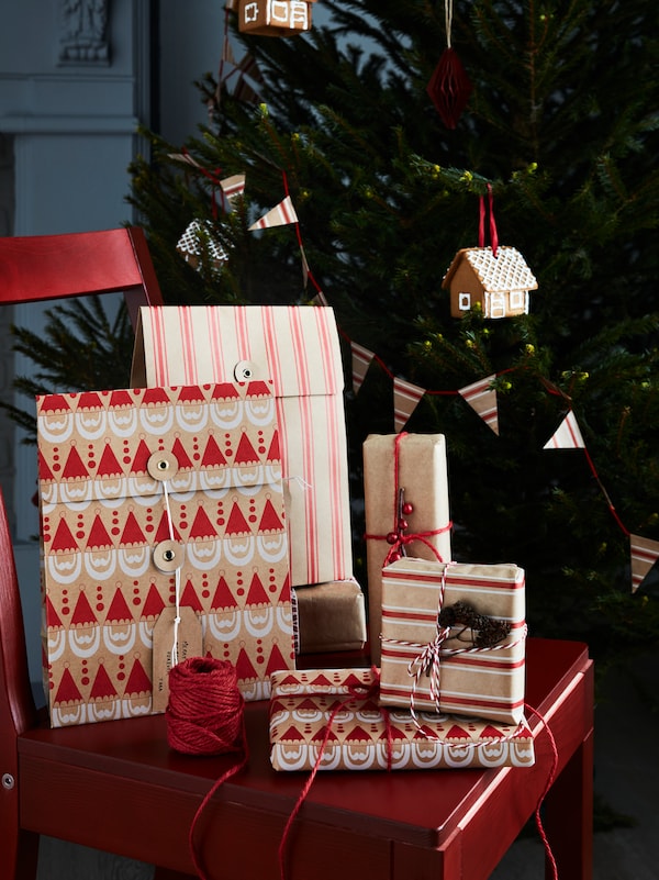 圣诞树前摆放着用VINTERFINT包装纸和绳子包裹的VINTERFINT礼品袋。