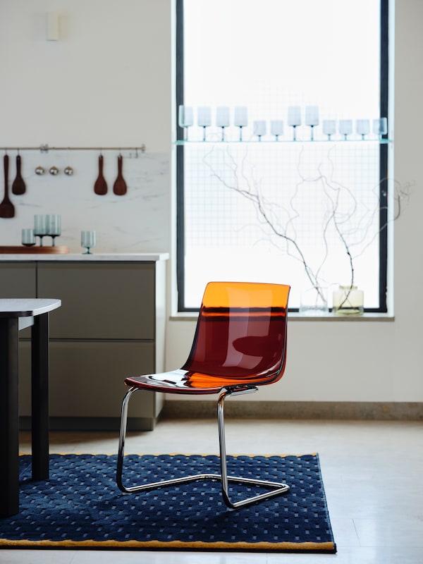 托拜厄斯椅子在棕色/红色/镀铬钢坐在窗口前海军纹理的地毯上明亮的厨房。
