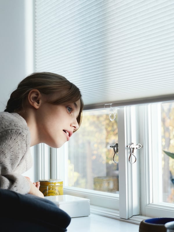 孩子穿着一件灰色毛衣身体前倾下凝视窗外其中HOPPVALS细胞盲。