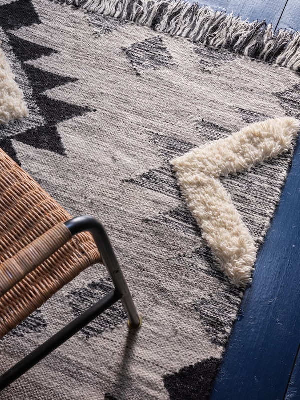 柳条椅子站在TANNISBY地毯在深浅的灰色,黑色和白色。