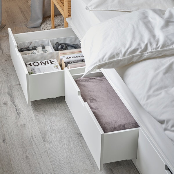 NORDLI床与存储ANGSLILJA床单。两个抽屉是开放和包含书籍、床罩和其他物品。