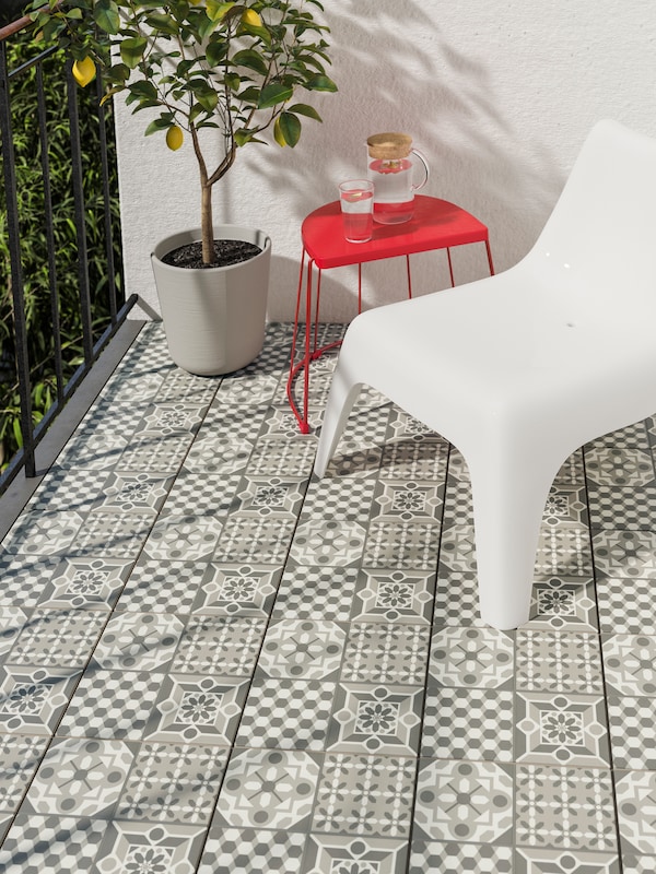 白色塑料户外带有红色户外餐桌和椅子在阳台上的盆栽植物设计的地板。