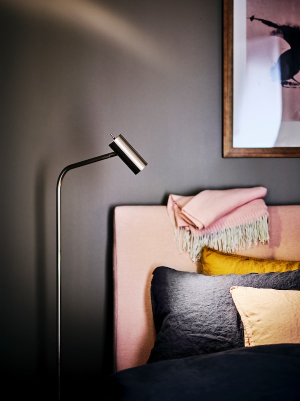VIRRMO地板/台灯旁边站一个淡粉色IDANAS软垫床DYTAG床单和额外的缓冲。