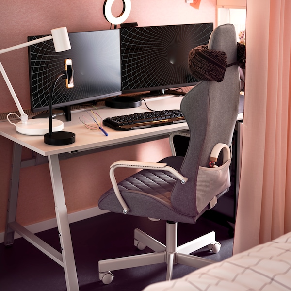 Bomstad灰色UTESPELARE游戏椅子在书桌前拿着两个显示器,一个环形光和一个白色NYMANE工作灯。