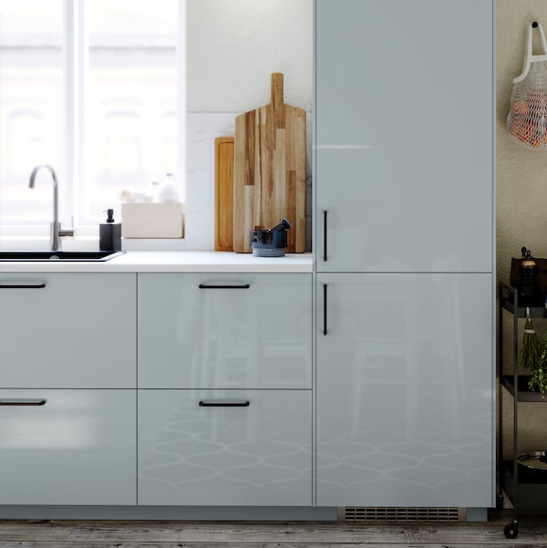 厨房与KALLARP浅灰蓝色厨房领域,双门冰箱,水槽和水龙头的窗口。