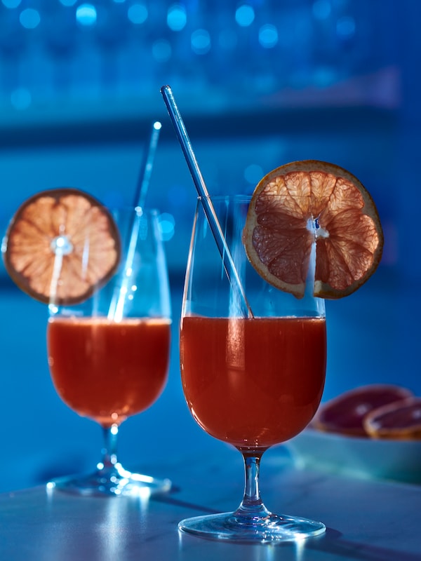 两杯STORSINT充满了红色的鸡尾酒和顶部有一片干橙。
