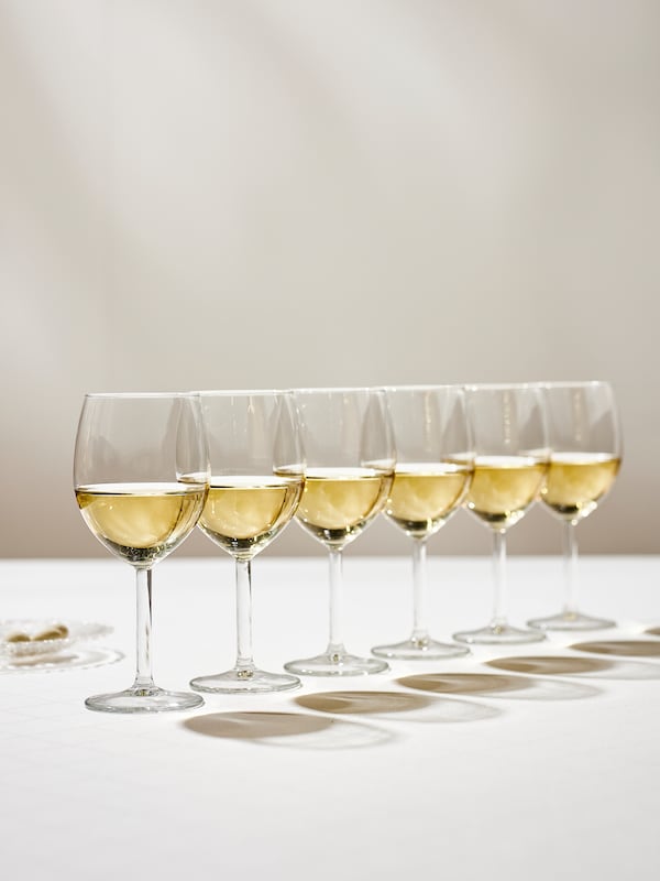 六SVALKA酒杯同样充满了白葡萄酒站在一排桌子上白色的桌布。
