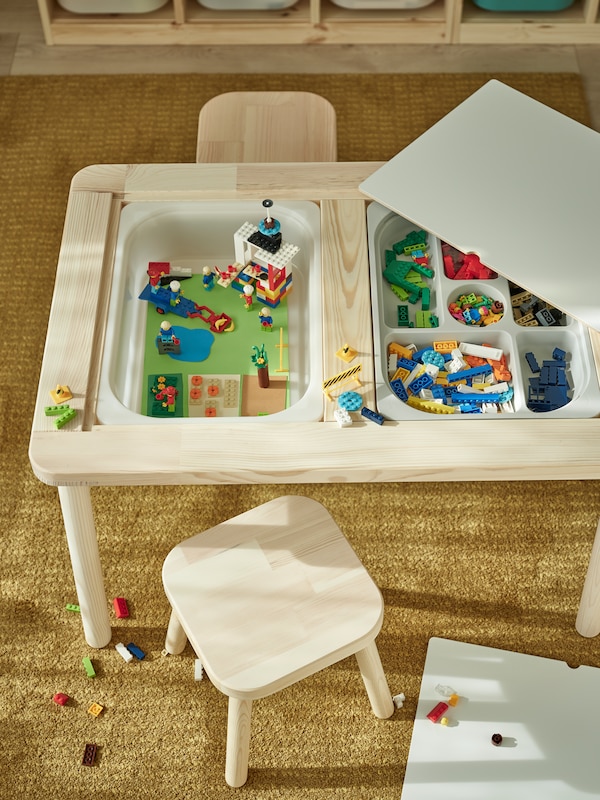 地中海Ett FLISAT barnbord av furu inbyggda forvaringslador地中海BYGGLEK乐高®比och tva barnpallar av furu。