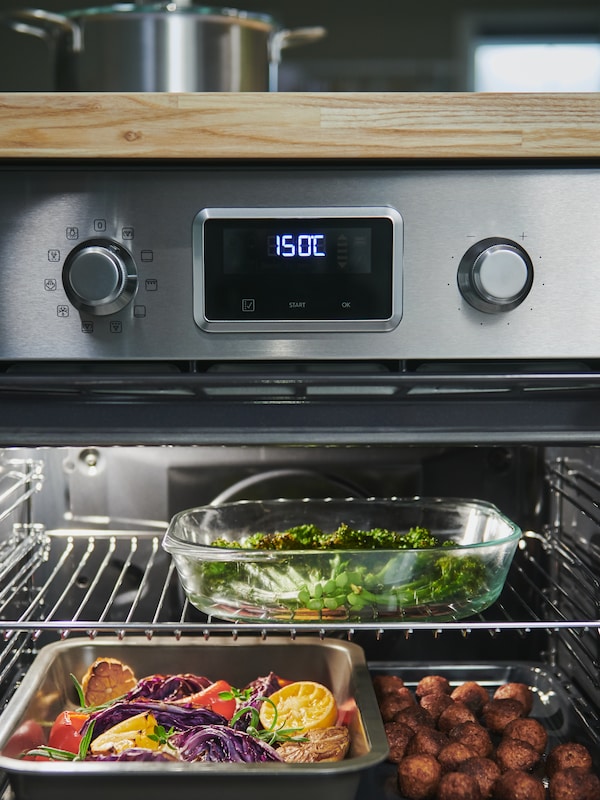 SMAKSAK强迫烤箱不锈钢托盘的什锦蔬菜、绿色蔬菜和肉丸里面做饭。