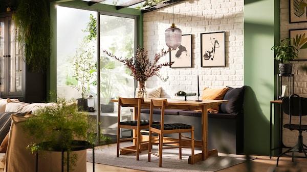 最小,industrial-style工作室用餐区组成的灰色GRASALA桌子和两把椅子在瓷砖墙上。