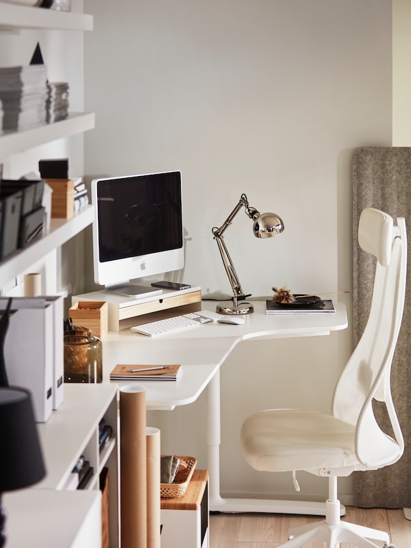 光空间和工作空间围绕一个白色的桌子和JARVFJALLET BEKANT角落办公椅。