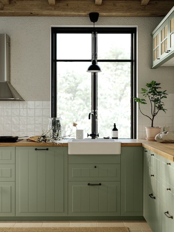 厨房与STENSUND厨房方面与窗口亮绿色,厨房电器和SKURUP吊灯在黑色的。