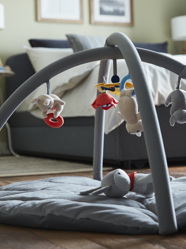 GULLIGAST plizana igraikka u obliku zeca na raznobojnoj GULLIGAST bebi- vekbalici u blizini HAUGA tapeciranog kreveta。