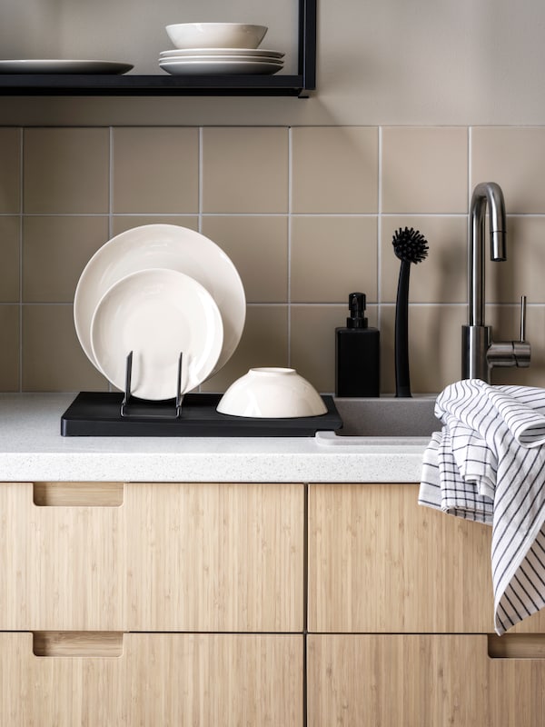 厨房水槽区域与RINNIG板持有人盘子和碗,RINNIG茶毛巾和洗菜刷灰。