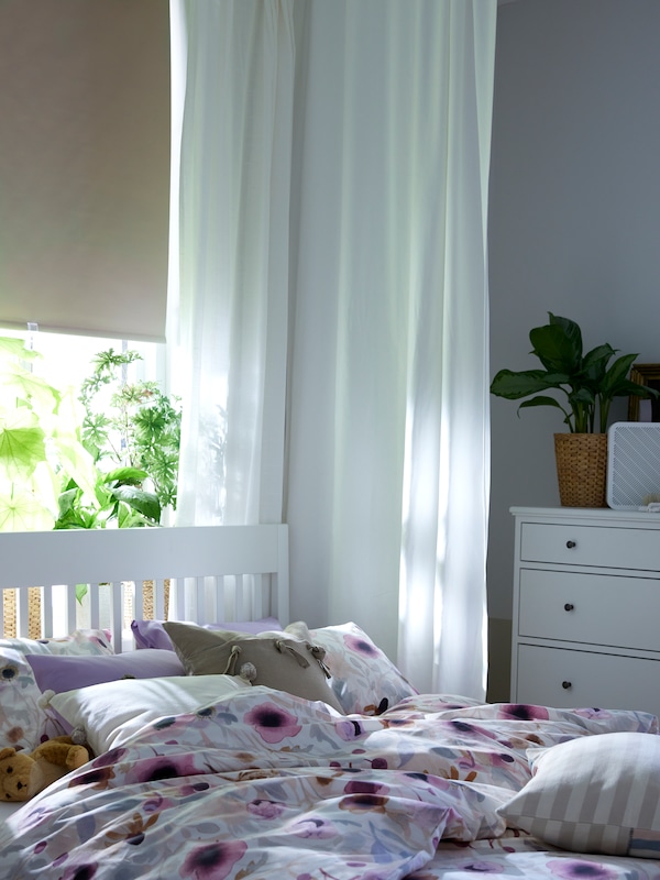 白色与LONNHOSTMAL IDANAS床床单站在窗口前FONSTERBLAD阻挡遮光窗帘。