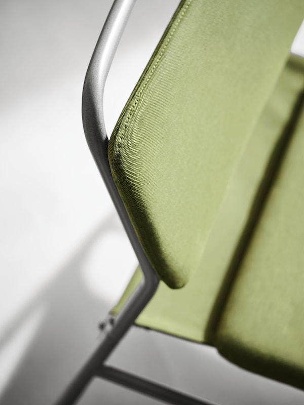 顶部的框架和靠背和座位LINNEBACK安乐椅上的黑色金属框架和一个橄榄绿色封面。