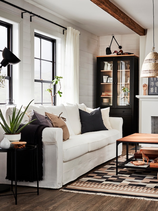 白色GRONLID 3三种座位沙发在传统风格的客厅玻璃门柜,有图案的地毯,和一个咖啡桌。