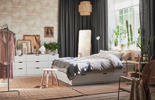 与北欧木材点燃卧室和白色设计展示NORDLI存储床架在中间白色房间的抽屉NORDLI衣柜靠的远端墙上。