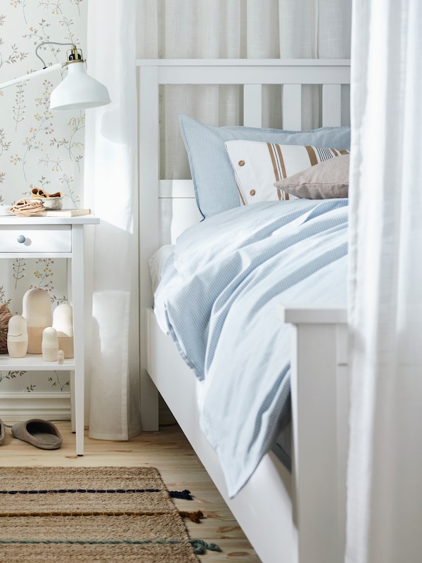 卧室灰色的墙壁与BJORKSNAS床框架包含一个床桦木、桦树和白色床单的床头柜。
