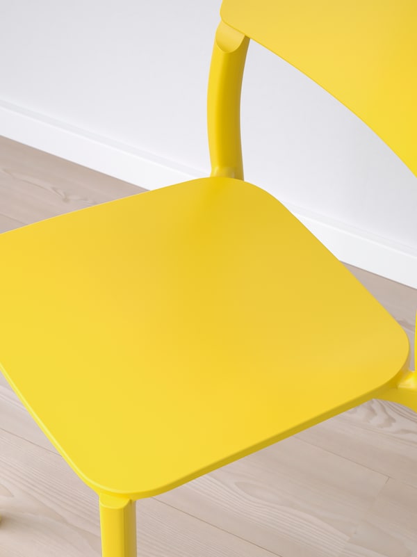 准备好组装,明亮的黄色JANINGE椅子站在面前的光木地板白墙。
