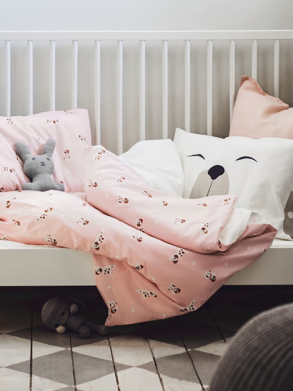 格列佛床一边删除一个粉红色DROMSLOTT床单,枕头狗图案和毛绒玩具。