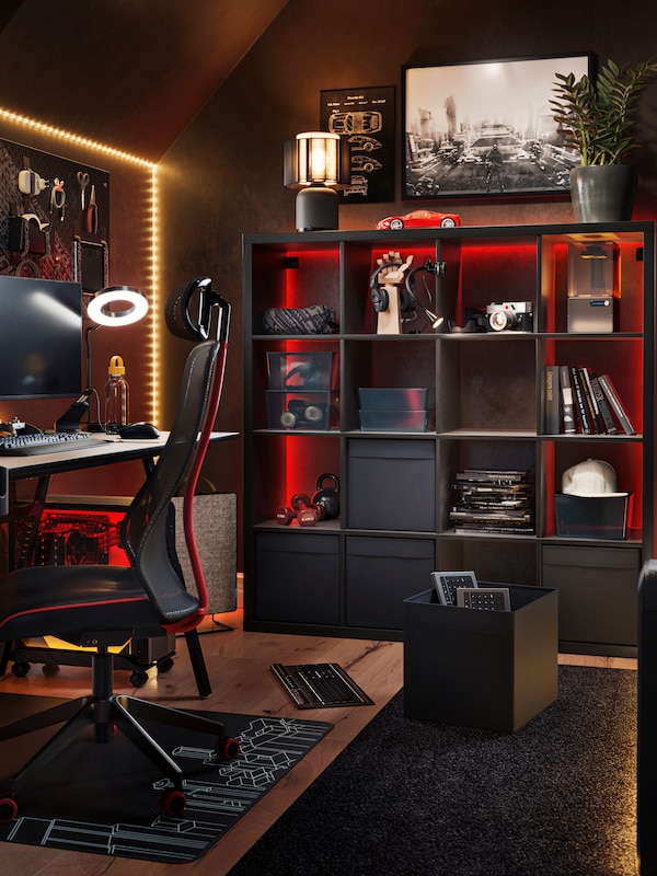 黑暗的游戏房间的黑褐色KALLAX搁置单元存储盒和游戏配件。
