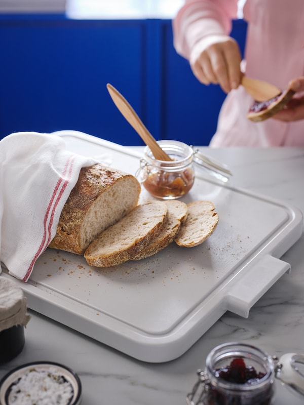浅灰色LILLHAVET案板,面包由HILDEGUN茶巾,SMORKLICK撒布机松在一个玻璃罐中。