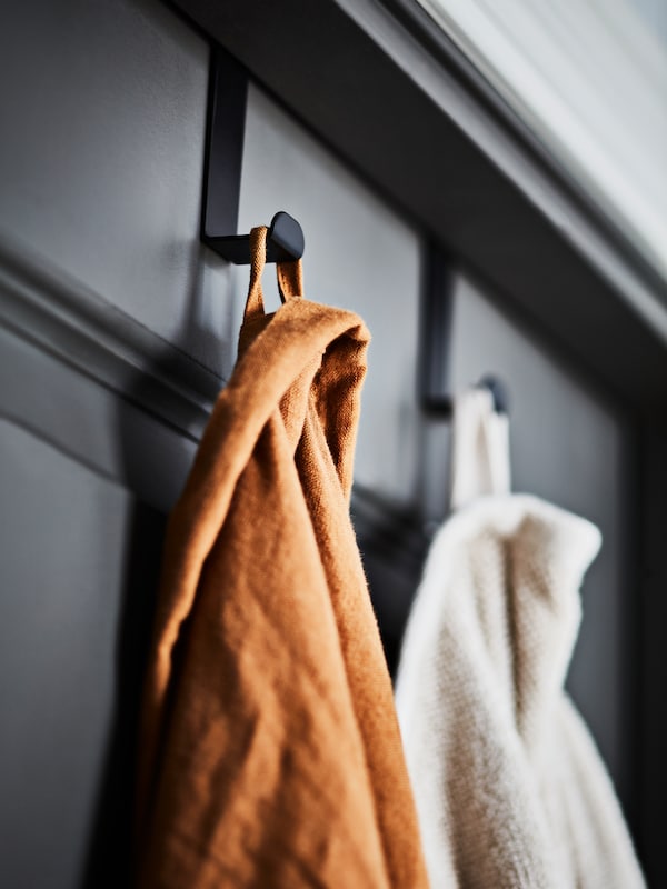两个黑SKOGSVIKEN门上的挂钩的深灰色,浅灰色/米色浴巾和浴袍。