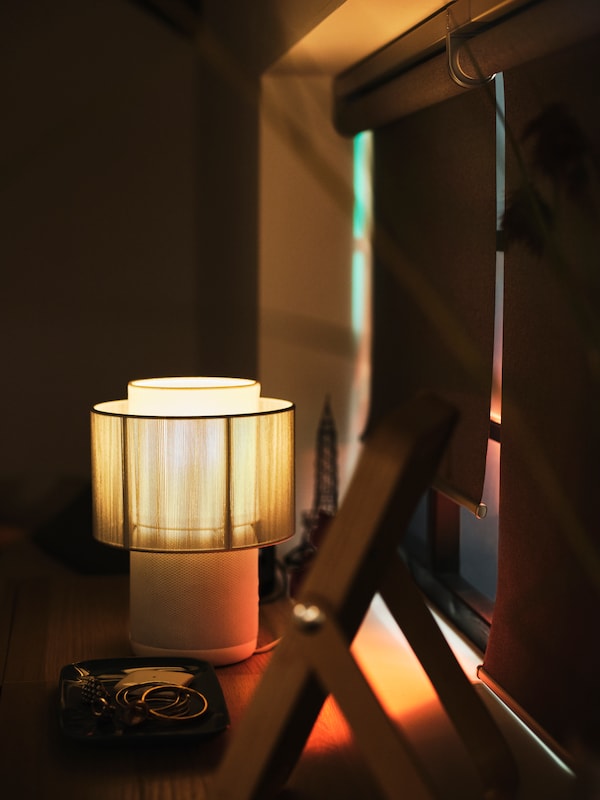 En tændt SYMFONISK højttalerlampe明星ved siden房颤等地中海vindue FYRTUR elektriske rullegardiner。