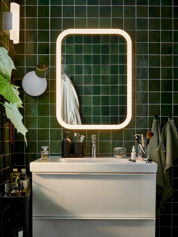 GODMORGON浴室柜在白色的高光泽和斯德哥尔摩绿色瓷砖墙上的镜子