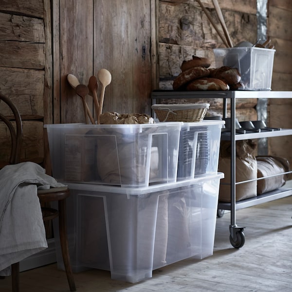 一个木屋内部用面粉袋、面包和烘焙配件在透明SAMLA存储盒和金属电车。