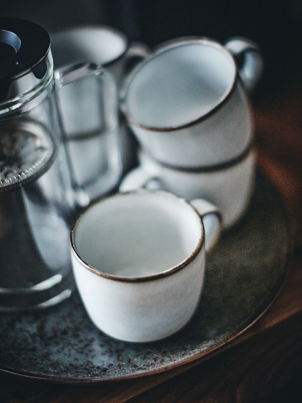 许多GLADELIG杯子在灰堆在另一个GLADELIG盘子和咖啡壶。