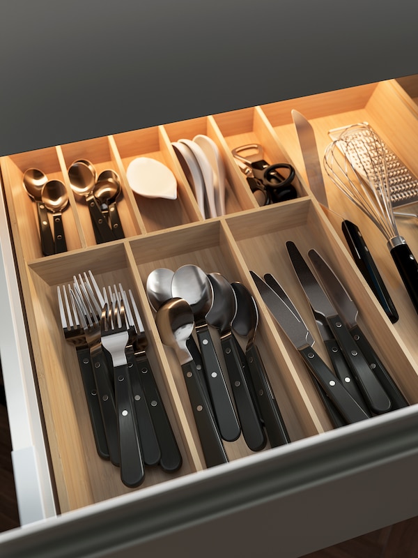开放的抽屉与UPPDATERA抽屉组织者根据竹刀,叉子,勺子和其他物品。