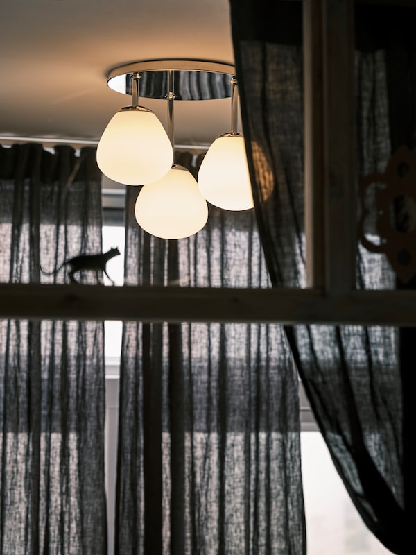 镀铬DEJSA天花板灯有三个opal-white玻璃颜色深灰色DYTAG旁边挂窗帘。