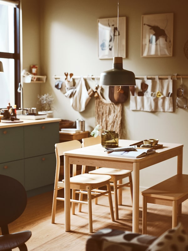 一个厨房和一个桦木RONNINGE可扩展表,下面两个桦木RONNINGE椅子和长凳上,一个吊灯。